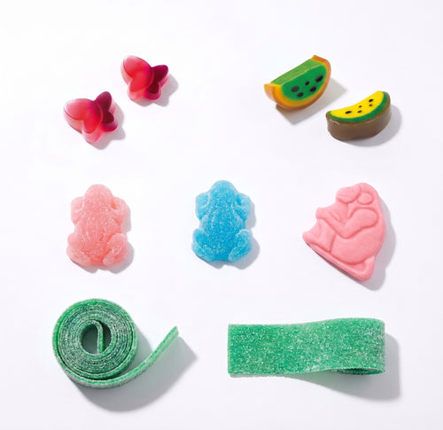 A collection of colorful sour candy pieces arranged on a clean white background, including pink and red butterfly-shaped candies, kiwi slice candies, pink and blue frog-shaped candies, a pink ape figure candy, a rolled green strip candy, and a green sugar-coated strip candy.