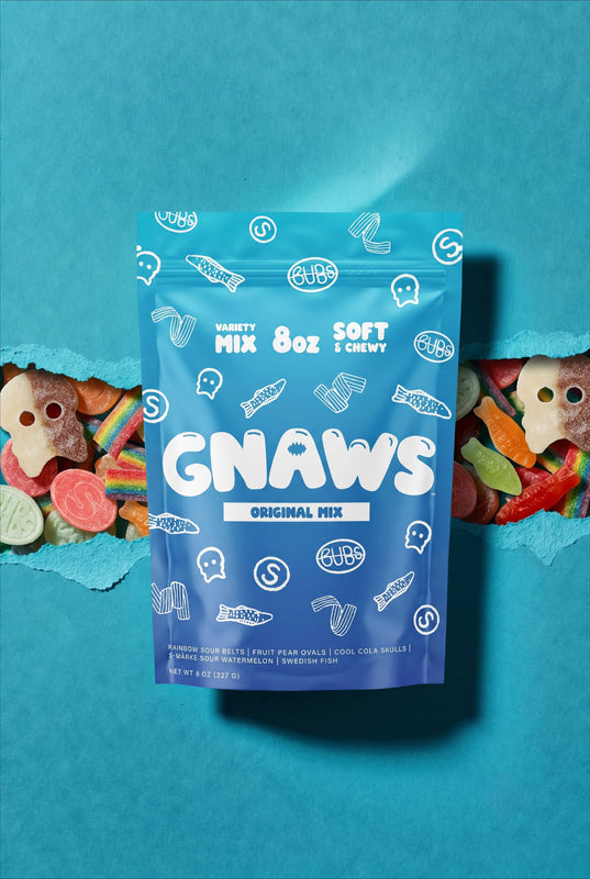 A blue stand-up pouch of GNAWS Original Mix candy sits centered against a teal-blue background, with torn paper edges on both sides revealing colorful gummy candies. The pouch has white text and candy-shaped line drawings.