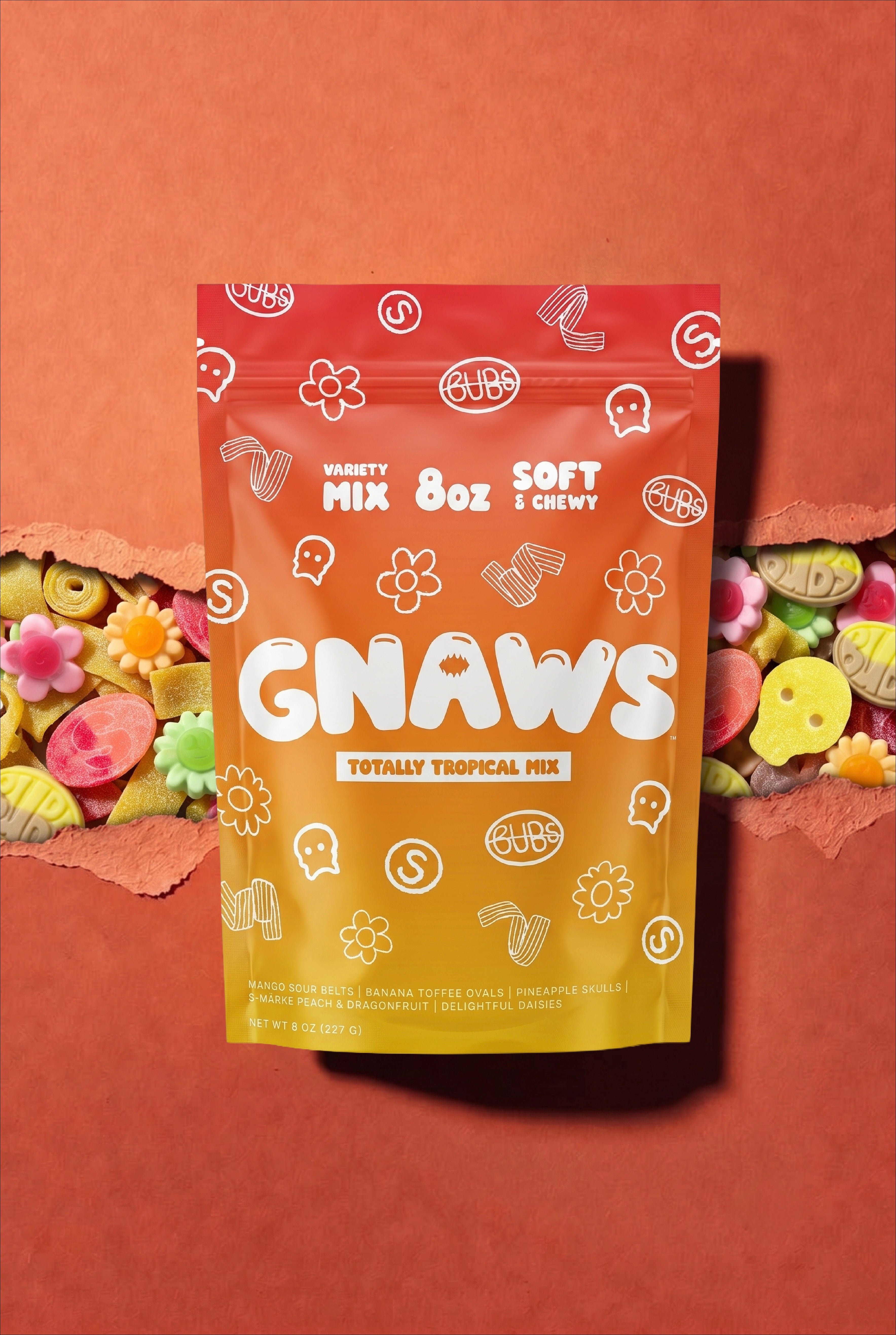 A stand-up pouch of GNAWS Variety Mix 8oz Soft & Chewy gummy treats, featuring a red-to-yellow gradient design with white doodle graphics, set against a terracotta background with torn paper revealing colorful treats inside.